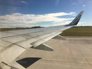 View of WestJet 737-700 wing and winglet while taxiing to runway at YYC