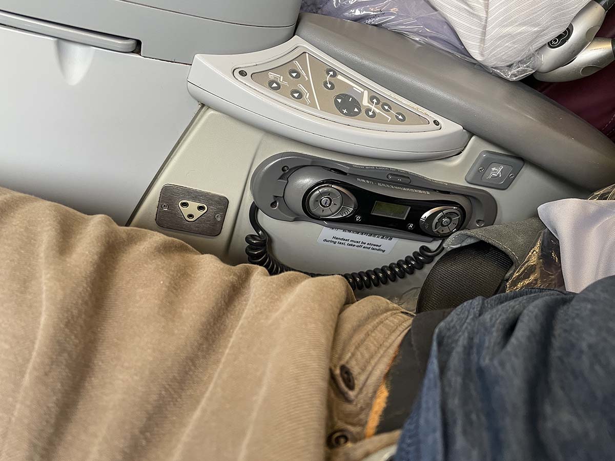 China Airlines A330-300 business class seat control buttons and remote control for the in-flight entertainment system integrated into the center armrest