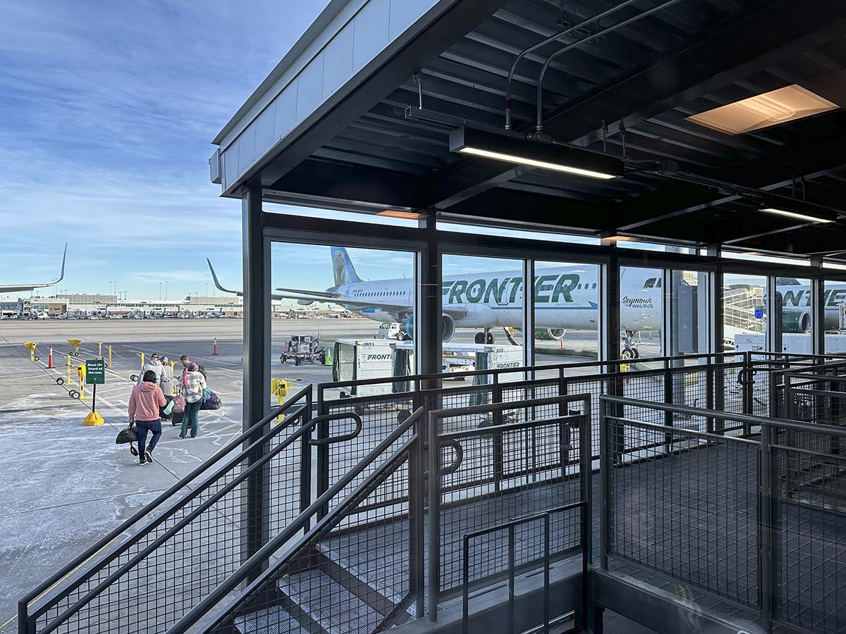 Passengers walking out on the ramp to board the aircraft Frontier Airlines gates concourse A Denver International Airport