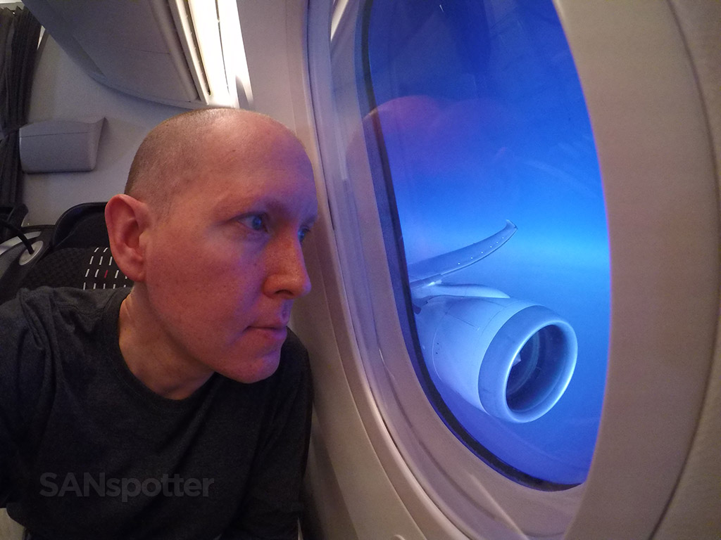 Scott looking out the window of a Japan airlines 787-8 from seat 3A